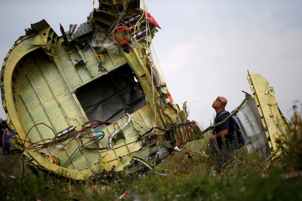 FILE PHOTO: A Malaysian air crash investigator inspects the crash site of Malaysia Airlines Flight MH17, near the village of Hrabove (Grabovo) in Donetsk region, Ukraine, July 22, 2014.  REUTERS/Maxim Zmeyev/File Photo