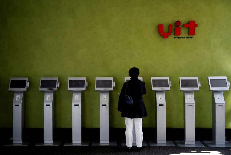 FILE PHOTO: A woman uses a ticket machine at Toho Cinemas' multiplex in Tokyo