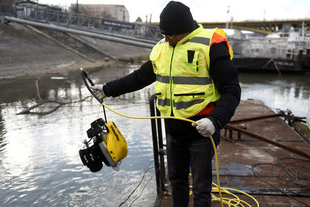 A volunteer of Israeli rescue and recovery organisation ZAKA pulls an underwater sonar from the Danube river during a search for the remains of Holocaust victims murdered on the banks of the river in 1944 in Budapest, Hungary January 15, 2019. REUTERS/Tamas Kaszas