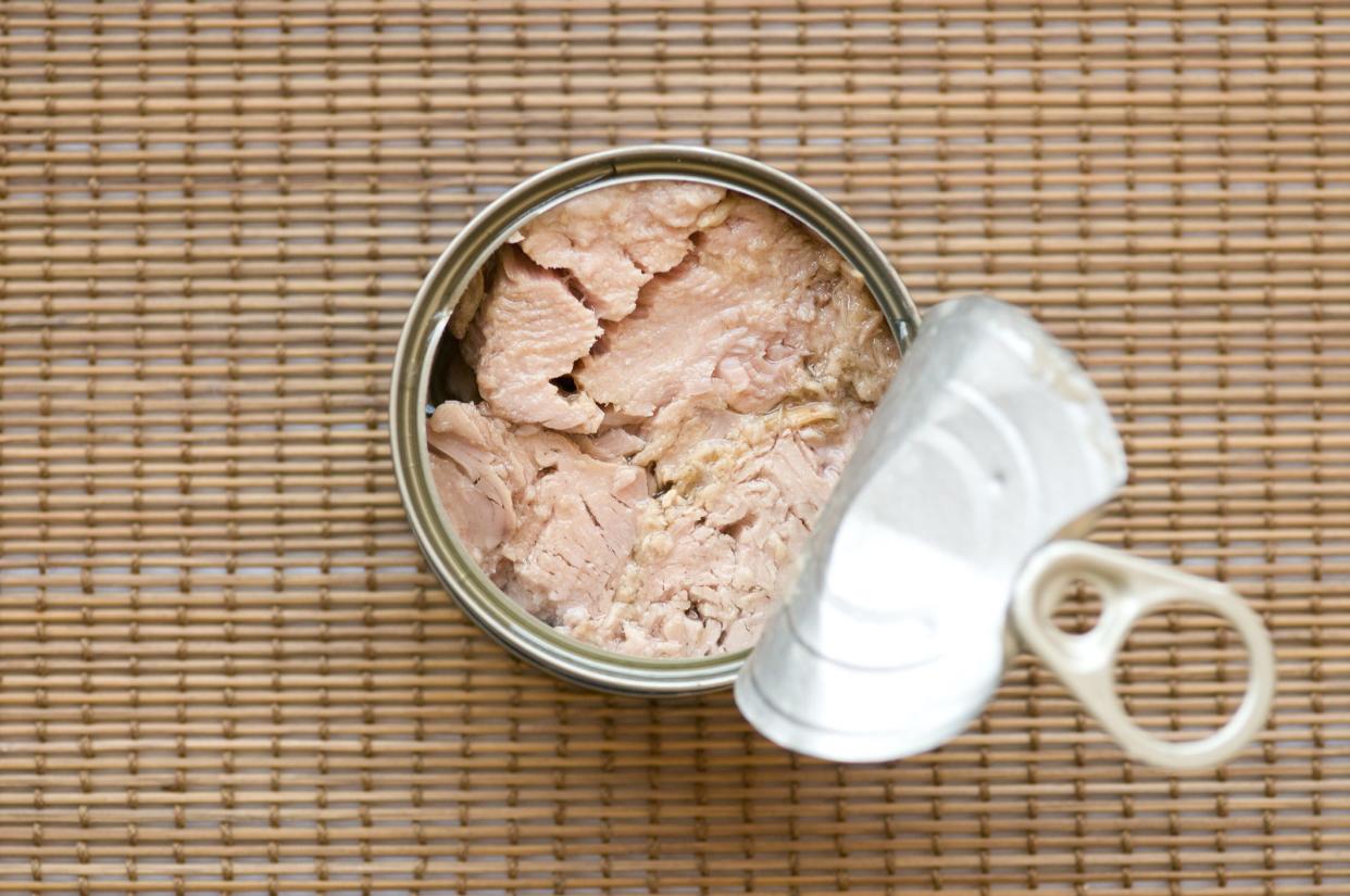 Tinned Tuna Fish. Ready for eat without cooking On a bamboo straw kitchen utensil surface.