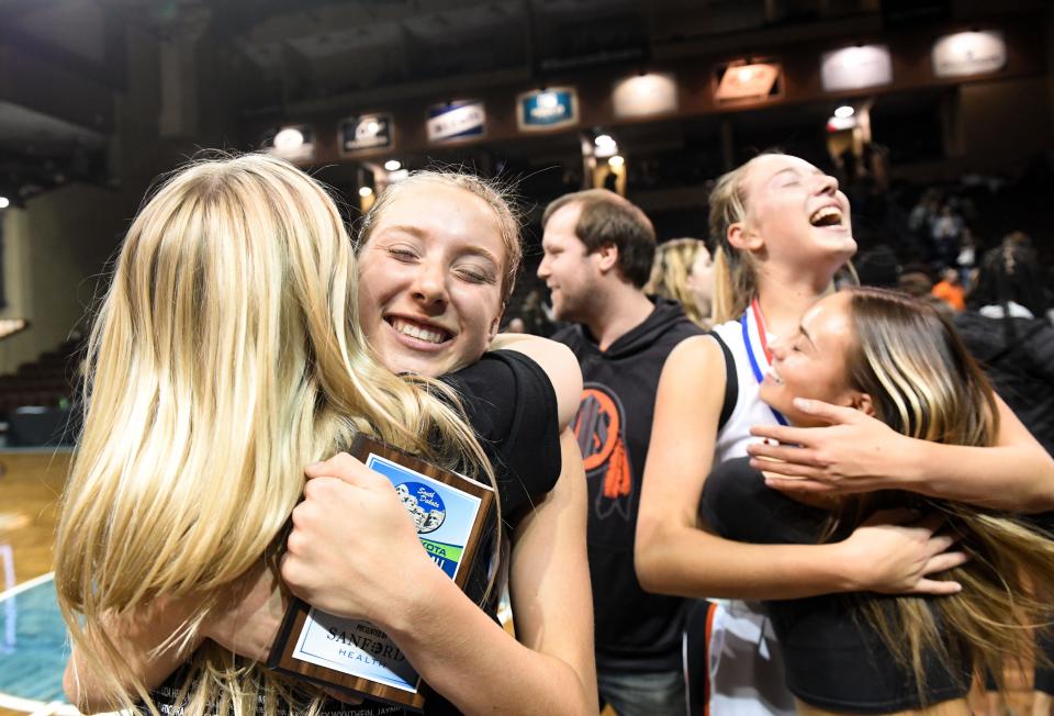 Twins Hannah and Brooklyn Harpe receive hugs from friends following the team’s win in the girls class AA state basketball championship on Saturday, March 11, 2023, at the Sanford Pentagon in Sioux Falls.