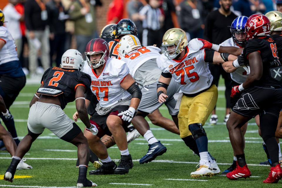 Offensive linemen Jake Andrews of Troy (77) and Jarrett Patterson of Notre Dame (75) face off against linebacker DeMarvion Overshown of Texas (2).