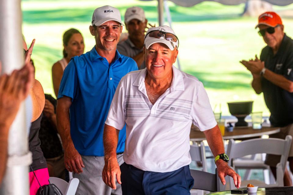 Jeffrey and Kevin Silva head to the stage to receive their trophy at the CCNB Fourball Tournament.