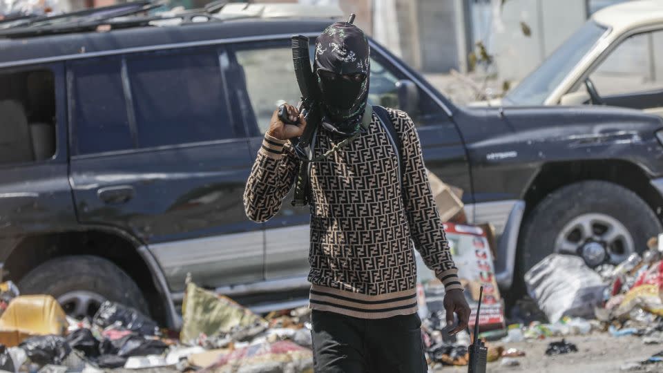 An armed member of the G9 and Family gang patrols a roadblock in Port-au-Prince on Monday. - Odelyn Joseph/AP