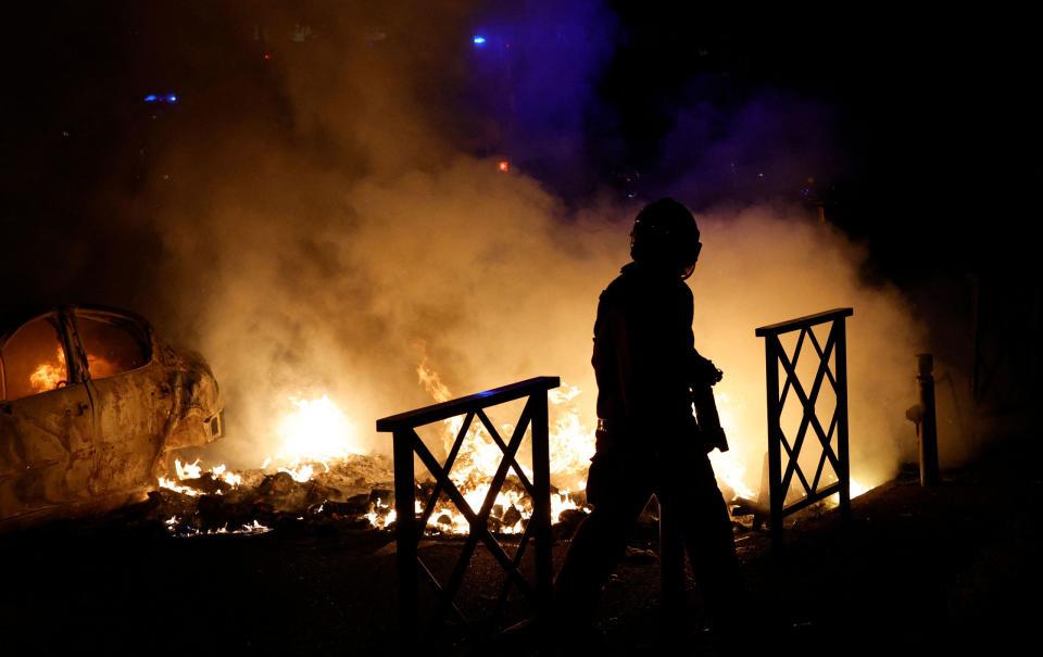 A firefighter extinguishes the flames of a car set on fire during protests in Nanterre in the early hours of June 29, 2023.<span class="copyright">Geoffroy Van der Hasselt—AFP/Getty Images</span>