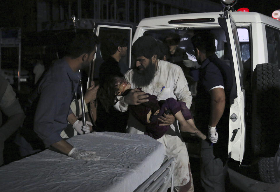 Afghan men carry an injured girl into the hospital after a large explosion in Kabul, Afghanistan, Monday, Sept. 2, 2019. Afghan officials say a large explosion in Kabul has targeted the Green Village compound, home to several international organizations and guesthouses. (AP Photo/Rahmat Gul)