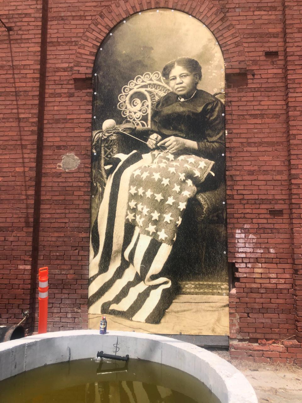 A historic picture hangs on the side of the Water Works building near the Enmarket Arena in west Savannah.