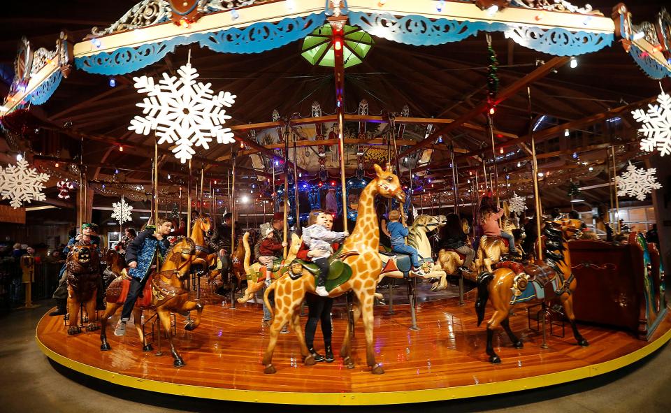 People ride the Carrousel at Richland Carrousel Park during Christmastime in the City in downtown Mansfield on Friday, Dec. 2, 2022. TOM E. PUSKAR/ASHLAND TIMES-GAZETTE