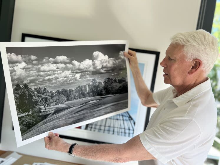 John Light sostiene una fotografía en blanco y negro que tomó del hoyo 16 en Los Ángeles Country Club.