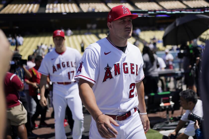 Los Angeles Angels' Mike Trout, right, and Shohei Ohtani enter the field during batting practice.