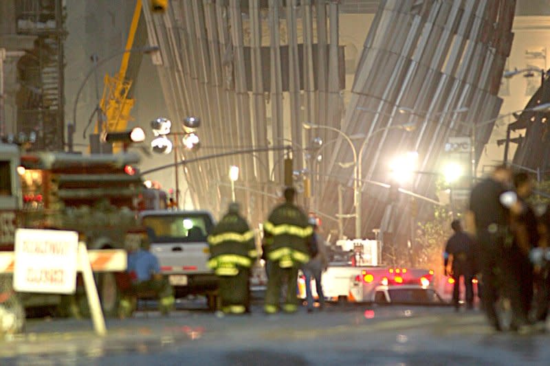 New York City firefighters observe the remnants of the World Trade Center's North Tower an hour before the sun began to rise over New York City the day after two hijacked commercial airplanes were flown into the Twin Towers, destroying the World Trade Center. File Photo by Steven E. Frischling/UPI