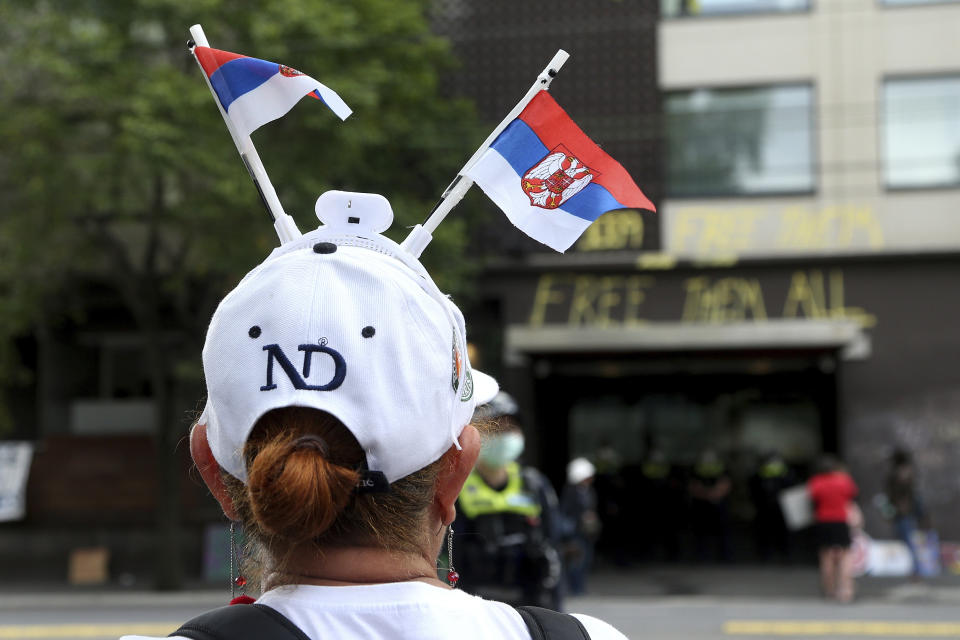 A protester and fan of Serbia's Novak Djokovic stands outside an immigration detention hotel where the tennis player is confined, in Melbourne, Australia, Saturday, Jan. 8, 2022. Djokovic has been confined to the detention hotel in Melbourne pending a court hearing on Monday, a week before the start of the Australian Open. He was barred from entering the country late Wednesday when federal border authorities at the Melbourne airport rejected his medical exemption to Australia's strict COVID-19 vaccination requirements. (AP Photo/Hamish Blair)