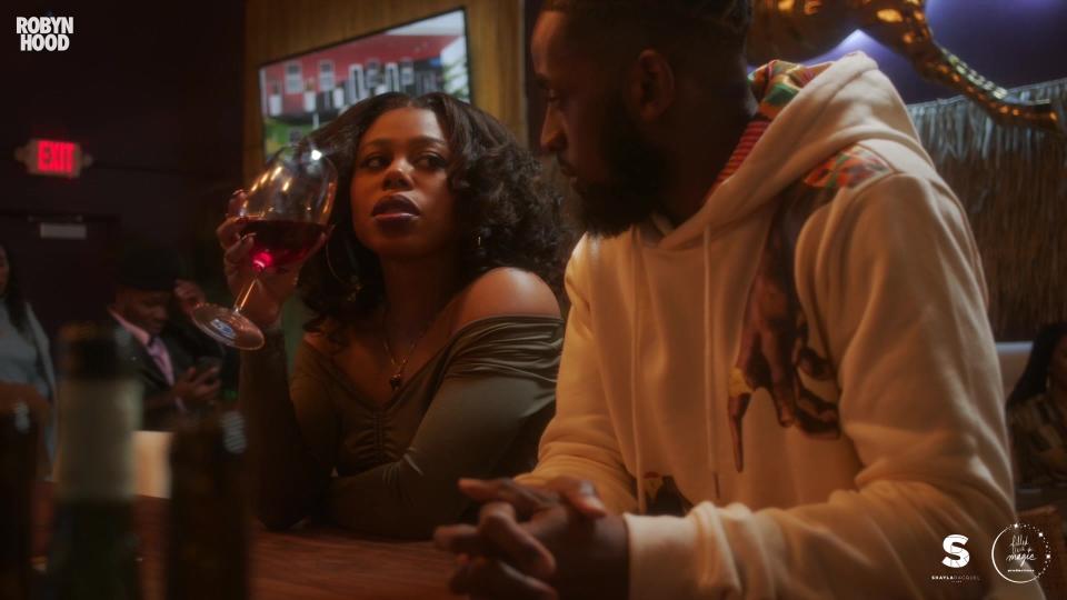 photo of a man wearing a white hoodie sitting beside a woman with curly hair in Robyn Hood horror short