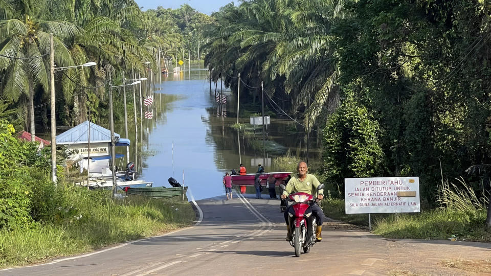 A main road is blocked by flood water at Lengga town in Johor state, Malaysia, Tuesday, March 7, 2023. Malaysian police have found the body of a young woman trapped in a car that was swept away by rushing waters, the fifth death of seasonal floods that have also forced more than 43,000 people to flee their homes. (AP Photo)