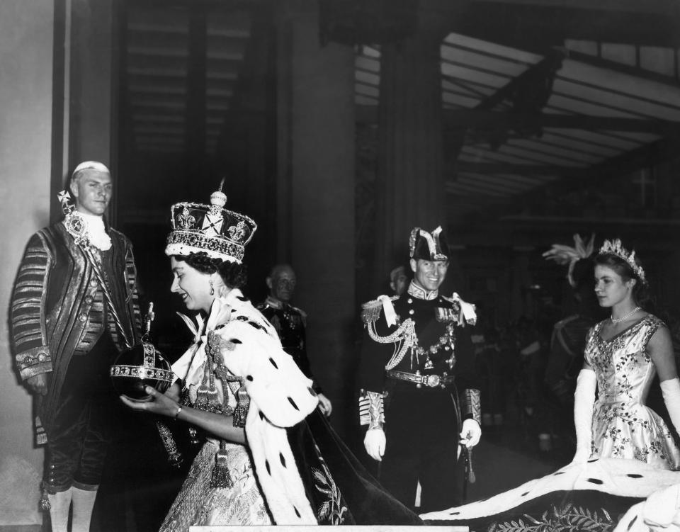 FILE - Britain's Queen Elizabeth II, carrying the orb and the scepter, enters Buckingham Palace after her Coronation ceremony in London's Westminster Abbey, June 2, 1953. The crowning of Charles and Camilla, the queen consort, will feature many of the elements of coronations past, the hymns, the prayers, the anointing with scented oils — all of which are designed to remind the world of the history, tradition and mystery embodied by the monarchy. (Pool via AP, File)