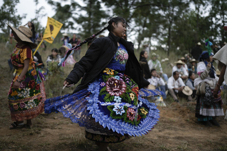 A Purepecha Indigenous woman dances during a rest stop by a group walking from Erongaricuaro, where residents kept a flame alive for one year and are taking it to Ocumicho in Michoacan state, Mexico, Wednesday, Jan. 31, 2024. A new fire will be lit in Ocumicho at the “New Fire” ceremony on Feb. 2 to mark the new year, after extinguishing the old fire on Feb. 1 which is considered an orphan day that belongs to no month and is used for mourning and renewal. (AP Photo/Eduardo Verdugo)