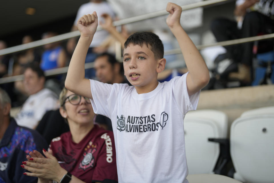 Gianluca Alvarez Sansalone, 10, with autism spectrum disorder, is accompanied by his mother Amanda Alvarez, as they watch a Brazilian soccer championship match between Corinthians and Cruzeiro at the Neo Quimica Arena in Sao Paulo, Brazil, Sunday, April 16, 2023. Brazilian soccer clubs are increasingly opening spaces for autistic fans to watch matches, mingle and celebrate the sport, an initiative that got even higher attention in April, when Autism Speaks celebrates World Autism Awareness Month. (AP Photo/Andre Penner)