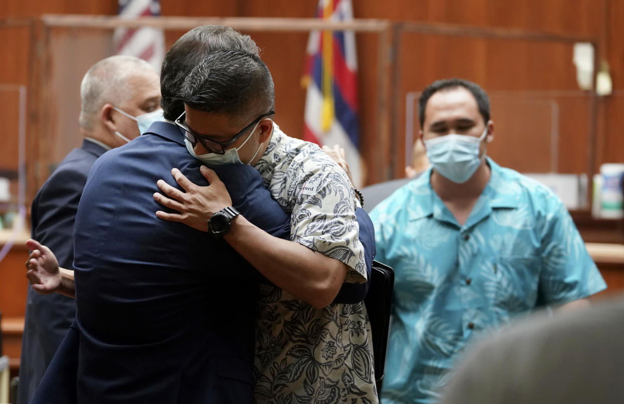 Honolulu Police officer Geoffrey Thom hugs a supporter after Judge William Domingo rejected murder and attempted murder charges against Thom and two fellow officers in the fatal shooting of a teenager, preventing the case from going to trial, Wednesday, Aug. 18, 2021, at district court in Honolulu. (Cory Lum/Honolulu Civil Beat via AP, Pool)