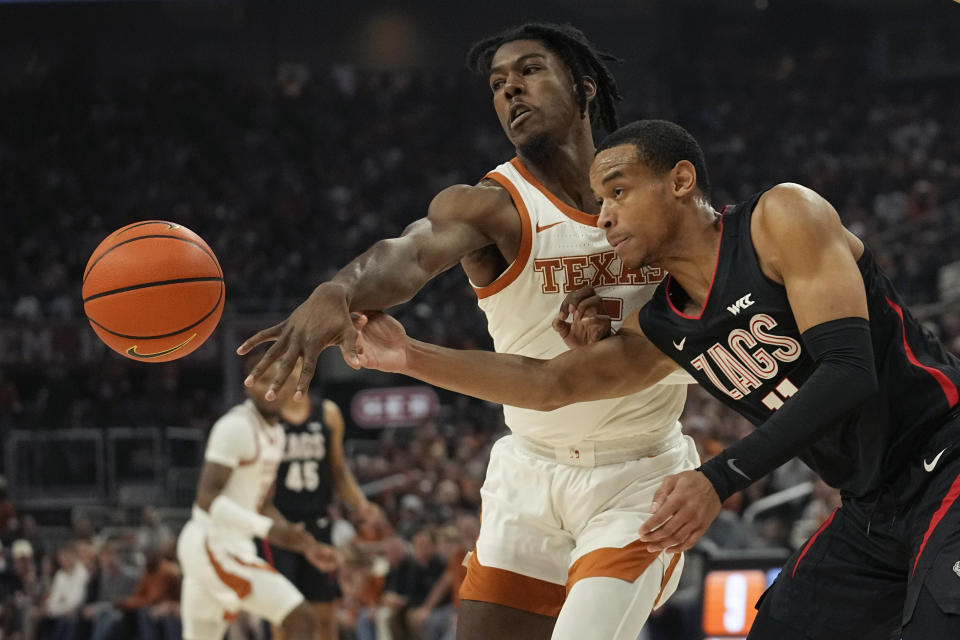 Texas guard Marcus Carr (5) and Gonzaga guard Nolan Hickman (11) chase a loose ball during the first half of an NCAA college basketball game, Wednesday, Nov. 16, 2022, in Austin, Texas. (AP Photo/Eric Gay)