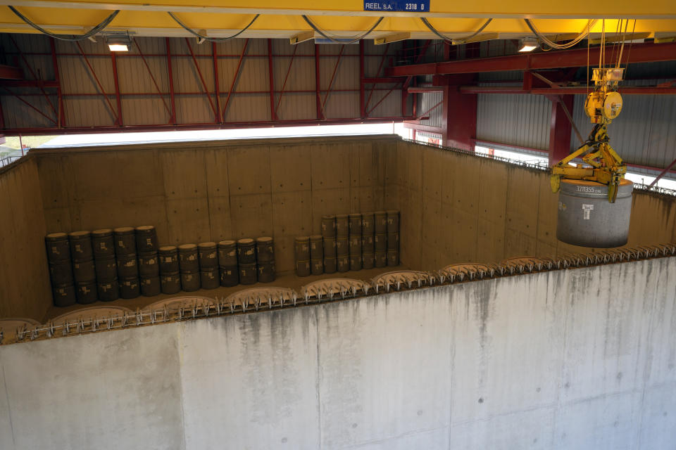 A radioactive waste storage is lifted in a concrete-sealed warehouse in the Aube region of eastern France managed by French radioactive waste management agency Andra, in Soulaines-Dhuys, Friday, Oct. 29, 2021. The site holds low- to mid-level radioactive waste from French nuclear plants as well as research and medical facilities, and its concrete-sealed warehouses are designed to store the waste for at least 300 years. (AP Photo/Francois Mori)