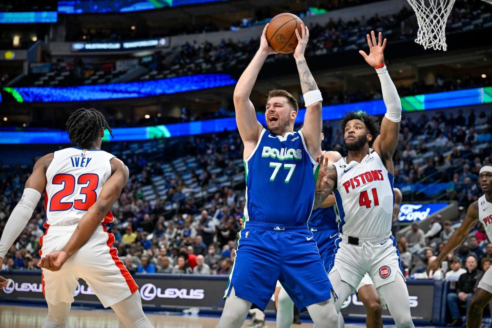 Mavericks guard Luka Doncic reacts to being stuck in the arm by Pistons guard Jaden Ivey, left, as forward Saddiq Bey looks to defend during the first quarter on Monday, Jan. 30, 2023, in Dallas.
