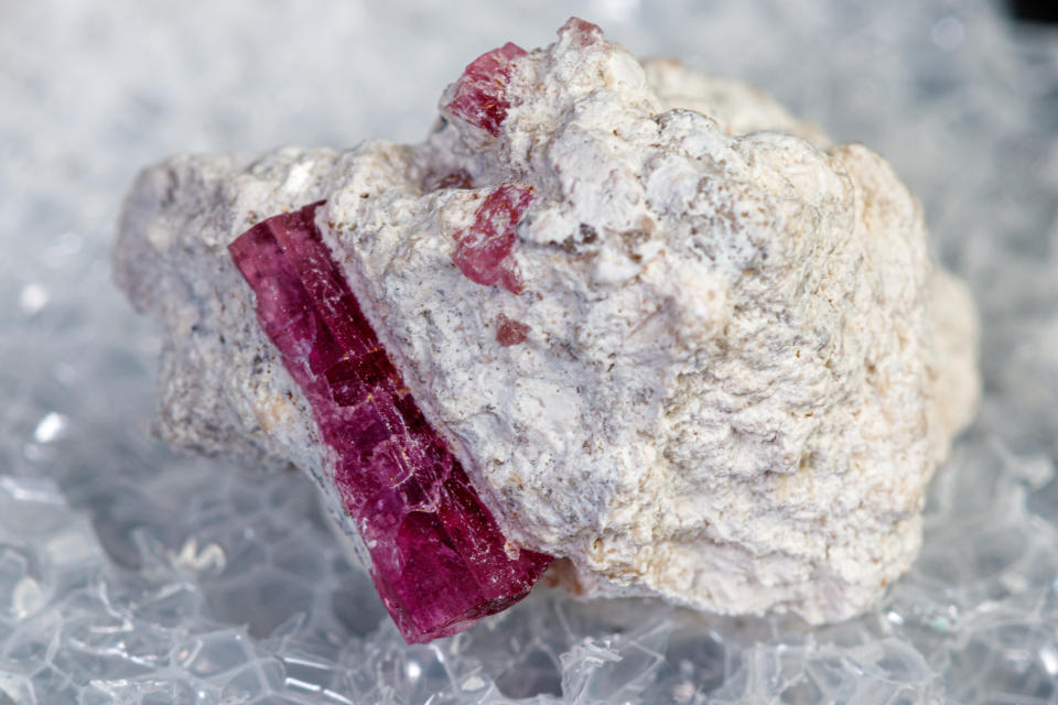 macro mineral stone red beryl on a black background close-up