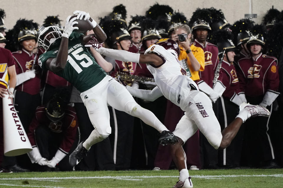 Michigan State wide receiver Jaron Glover (15), defended by Central Michigan defensive back Lavario Wiley (6) pulls in a pass at the three-yard line during the first half of an NCAA college football game, Friday, Sept. 1, 2023, in East Lansing, Mich. (AP Photo/Carlos Osorio)
