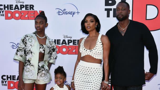 PHOTO: Gabrielle Union (2R) and Dwayne Wade pose with daughters Zaya Wade (L) and Kaavia James Union Wade (2L) as they arrive for the 'Cheaper by the Dozen' Disney premiere at the El Capitan theatre in Hollywood, Calif., March 16, 2022. (Chris Delmas/AFP via Getty Images)