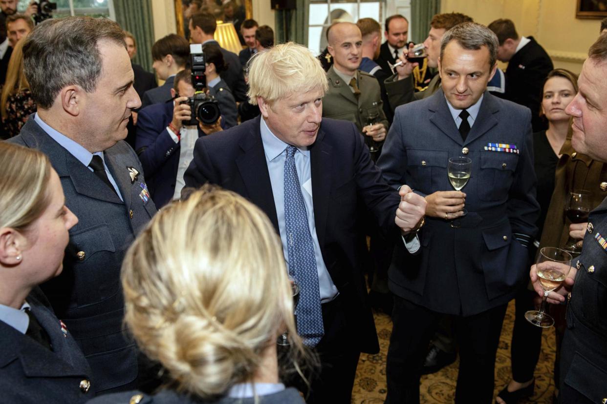 Boris Johnson, centre, speaks to guests at a military reception held at 10 Downing Street on Wednesday night: AP