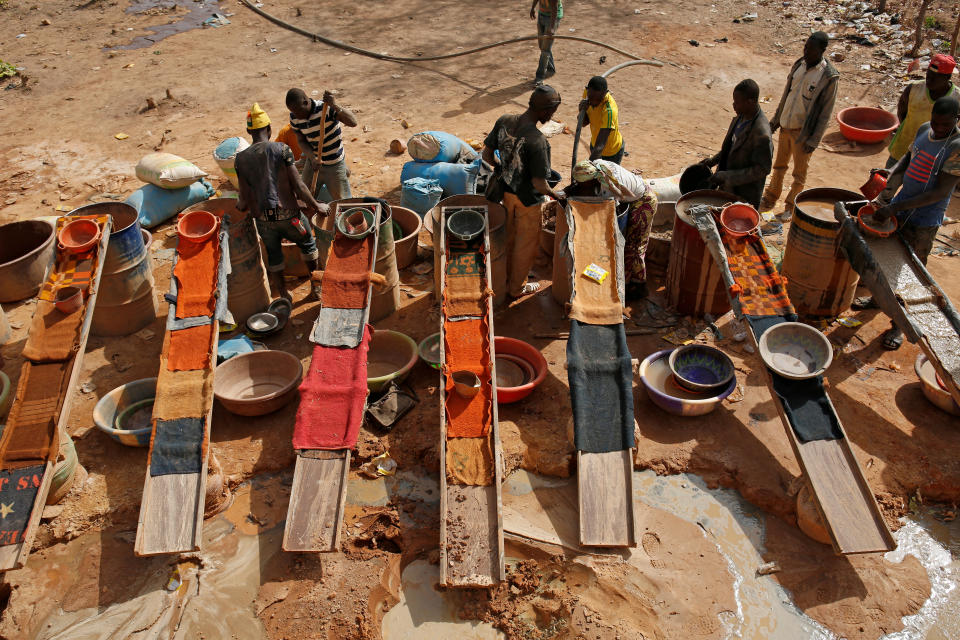 FILE PHOTO: Artisanal miners sluice for gold by pouring water through gravel at an unlicensed mine near the city of Doropo, Ivory Coast