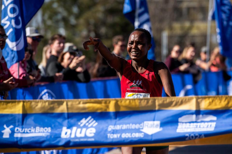 Betty Sigei points as she crosses the finish line, placing first during the Horsetooth Half Marathon on Sunday in Fort Collins.