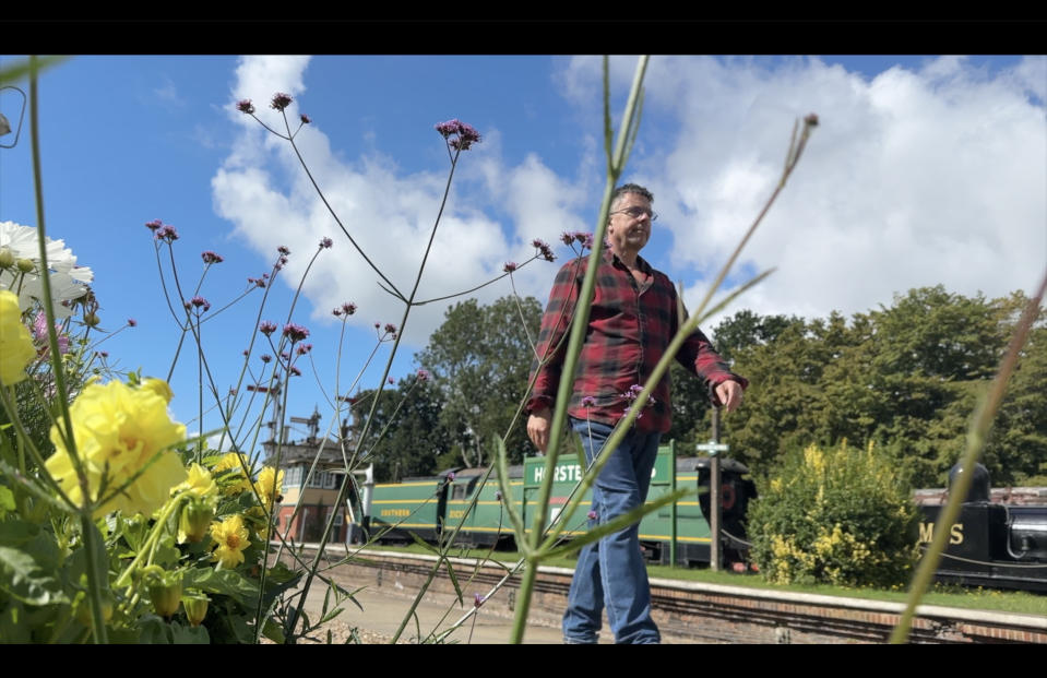 Man walking past plants