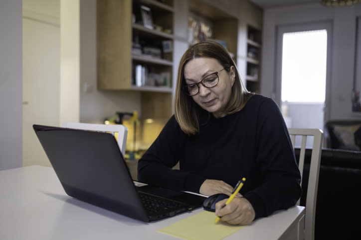 A woman making a list of questions to identify the best type of retirement annuity for her needs.