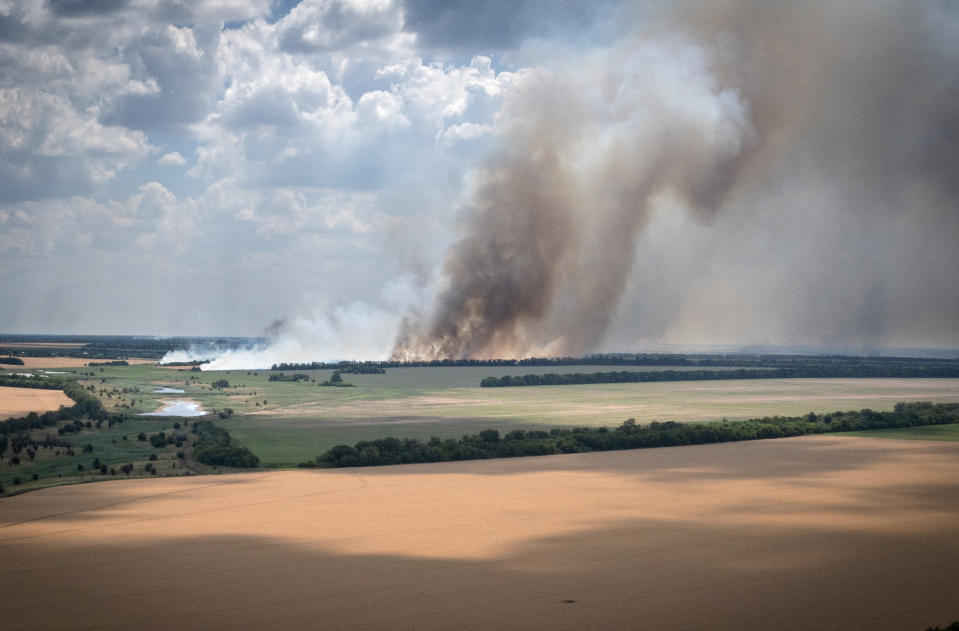 Smoke rises from the front lines where fierce battle is going between Ukrainian and Russian troops, farmer fields in the foreground, in the Dnipropetrovsk region, Ukraine, Monday, July 4, 2022. An estimated 22 million tons of grain are blocked in Ukraine, and pressure is growing as the new harvest begins. The country usually delivers about 30% of its grain to Europe, 30% to North Africa and 40% to Asia. But with the ongoing Russian naval blockade of Ukrainian Black Sea ports, millions of tons of last year’s harvest still can’t reach their destinations. (AP Photo/Efrem Lukatsky)