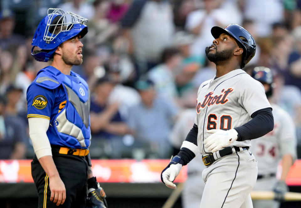 Detroit Tigers' Akil Baddoo (60) crosses home plate after hitting a solo home run, next to Seattle Mariners catcher Tom Murphy during the fifth inning of a baseball game Friday, July 14, 2023, in Seattle. (AP Photo/Lindsey Wasson)