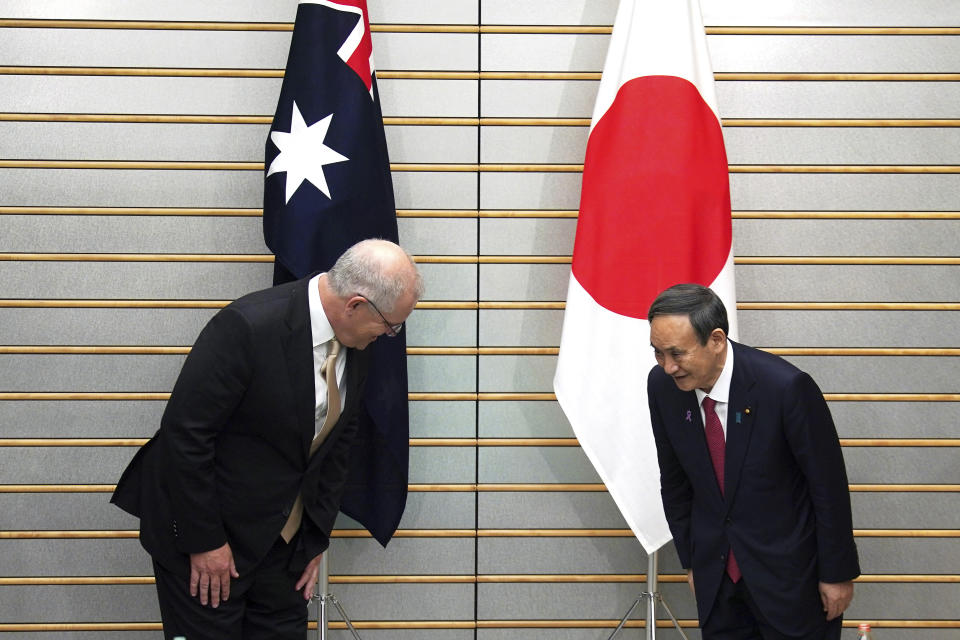 Australian Prime Minister Scott Morrison, left, and his Japanese counterpart Yoshihide Suga bow each other at the start of their meeting at Suga's official residence in Tokyo Tuesday, Nov. 17, 2020. Morrison is in Japan to hold talks with his Japanese counterpart, Yoshihide Suga, to bolster defense ties between the two U.S. allies to counter China’s growing assertiveness in the Asia-Pacific region. (AP Photo/Eugene Hoshiko, Pool)
