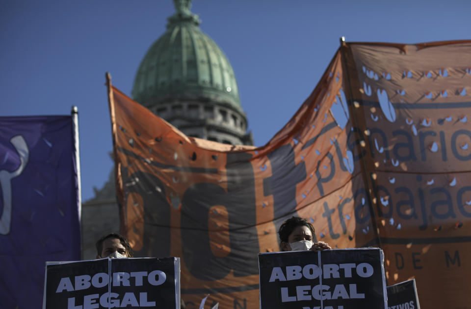 Activistas en favor del aborto sostienen letreros durante una protesta que apoya su despenalización afuera del Congreso en medio de una cuarentena para bajar la curva del contagios del nuevo coronavirus en Buenos Aires, Argentina, el jueves 28 de mayo de 2020. (AP Foto/Natacha Pisarenko)