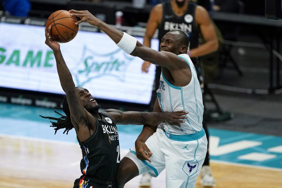 Charlotte Hornets center Bismack Biyombo blocks a shot by Brooklyn Nets forward Taurean Prince, left, during the first half of an NBA basketball game in Charlotte, N.C., Sunday, Dec. 27, 2020. (AP Photo/Chris Carlson)