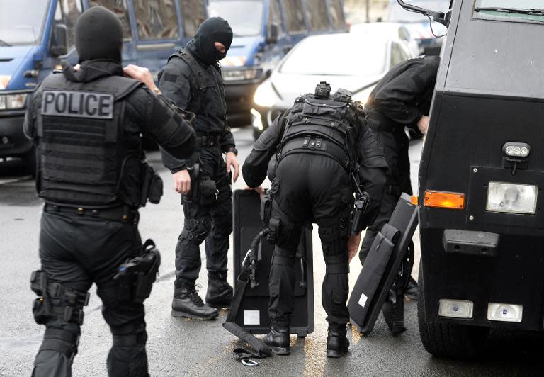 Members of the French national police intervention group (BRI) prepare their gear before leaving on operation in front of Paris' police headquarters