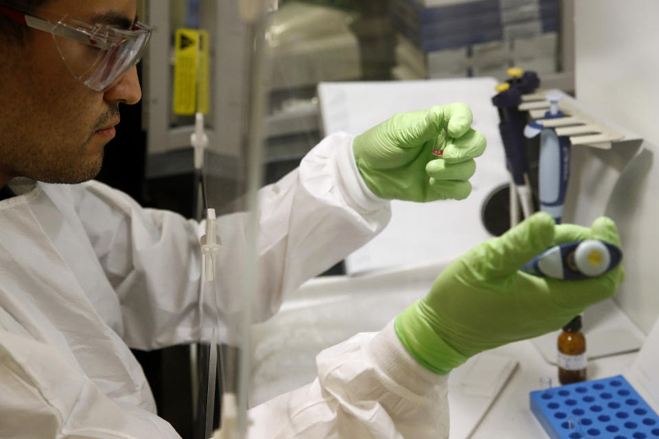 In this June 27, 2019 photo, document analysis technician Irvin Rivera works with a sample of inkjet printer ink in the International Ink Library at the U.S. Secret Service headquarters building in Washington. The library was recently dedicated to Antonio Cantu, a renowned investigator and former chief chemist at the Secret Service who started picking up samples decades ago. (AP Photo/Patrick Semansky)