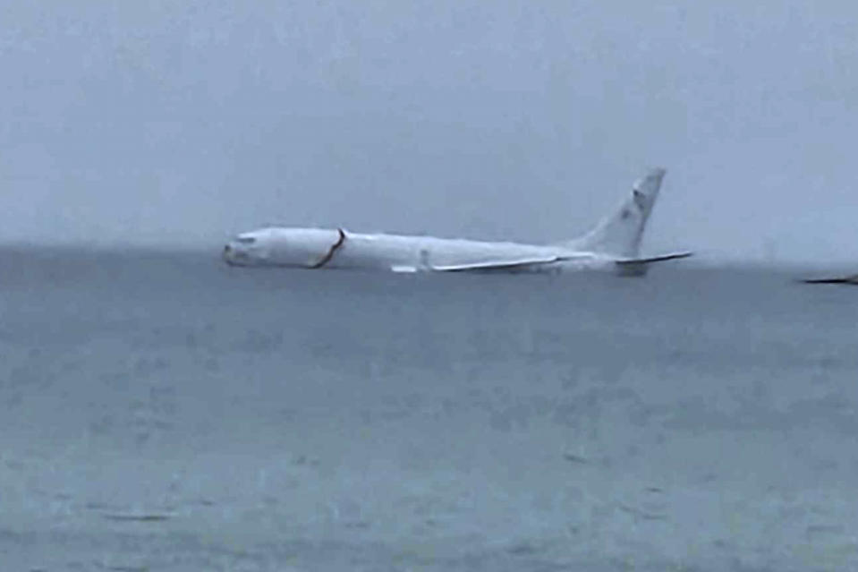 This photo provided by Diane Dircks shows a U.S. Navy plane that overshot a Marine base on Kaneohe Bay, Hawaii, Monday, Nov. 20, 2023. An official says all nine people aboard the plane have escaped injury. (Diane Dircks via AP)