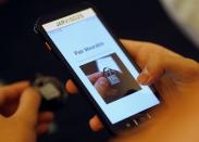 A staff member pairs a movement-tracking "Safelet" device to an attendee at the Geo Connect Asia conference in Singapore