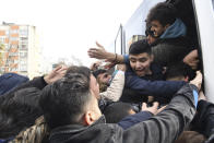 Migrants struggle to board a bus to go to the Greek border, in Istanbul, Friday, Feb. 28, 2020. NATO envoys were holding emergency talks Friday at the request of Turkey following the killing of 33 Turkish soldiers in northeast Syria, as scores of migrants gathered at Turkey's border with Greece seeking entry into Europe. (AP Photo/Omer Kuscu)