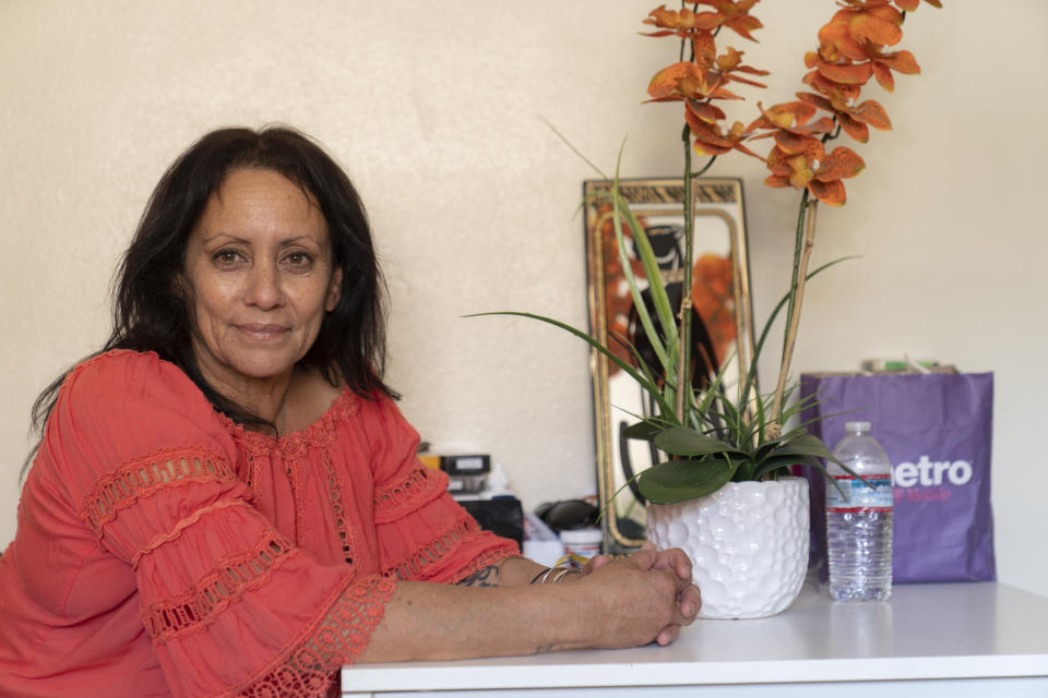 In this Wednesday, June 30, 2021, photo Veronica Perez poses at her new home at the Mollie Mason Project Homekey site in Los Angeles. At her new home, Perez relishes her privacy and appreciates the fact she was allowed to bring "The told us, make yourself feel at home. And I do," she said. Perez was diagnosed with PTSD and receives counseling for that. Staff have also helped her apply for a new Social Security card and will help her find a job when she's ready. (AP Photo/Damian Dovarganes)