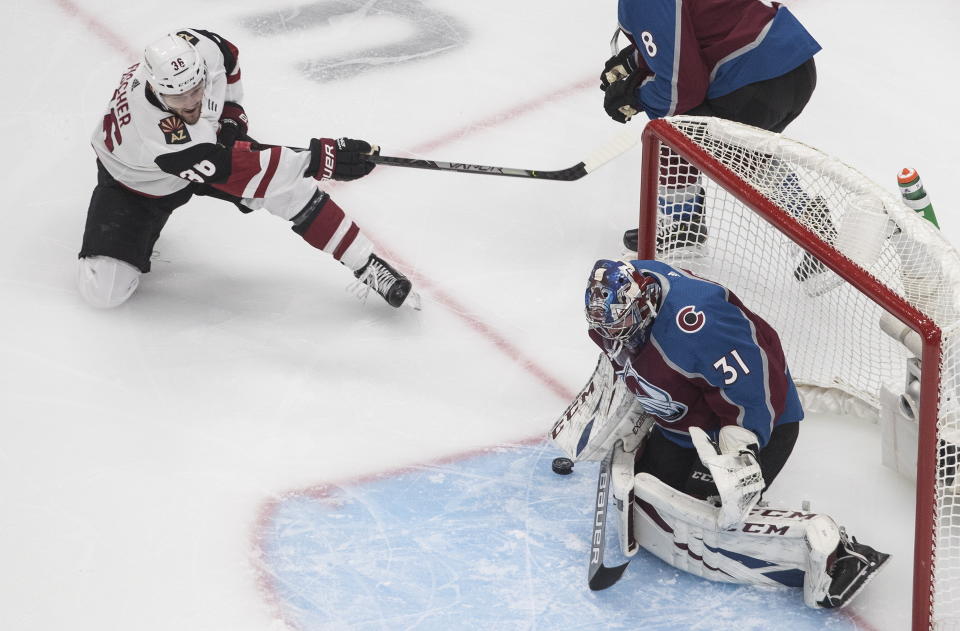 Arizona Coyotes' Christian Fischer (36) is stopped by Colorado Avalanche goalie Philipp Grubauer (31) during the first period of a first round NHL Stanley Cup playoff hockey series in Edmonton, Alberta, Friday, Aug. 14, 2020. (Jason Franson/The Canadian Press via AP)