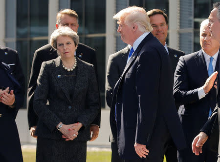 U.S. President Donald Trump (R) walks past Britain's Prime Minister Theresa May at the start of the NATO summit at their new headquarters in Brussels, Belgium, May 25, 2017. REUTERS/Jonathan Ernst