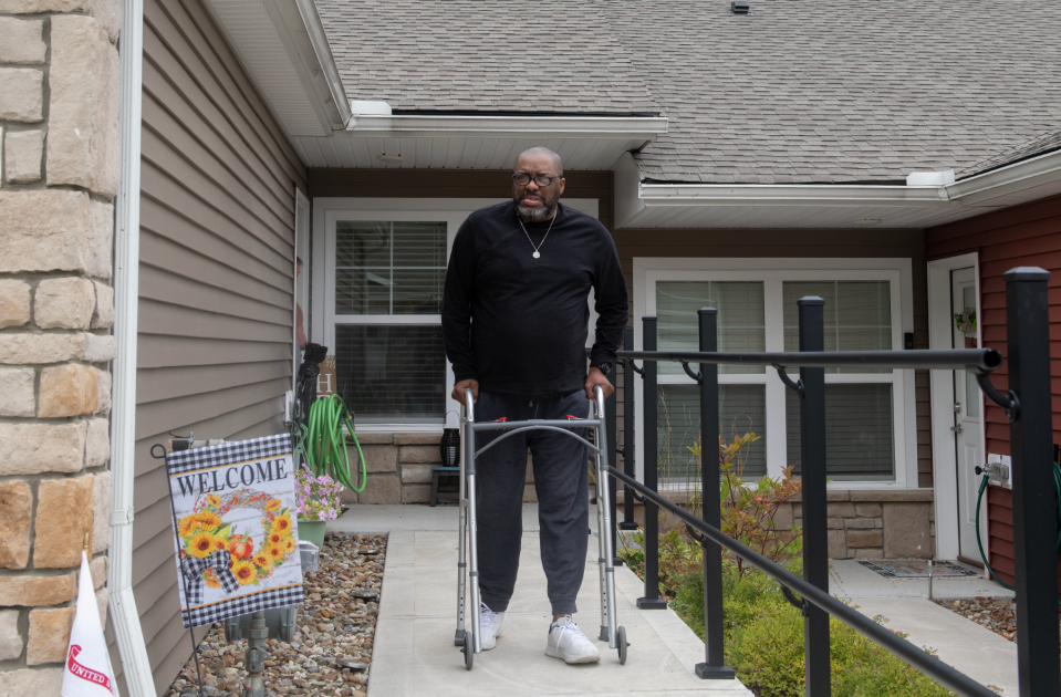 David Upshaw uses a walker to leave his house for dialysis treatments.