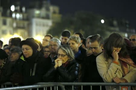 People gather outside Notre Dame Cathedral where a mass is held following a series of deadly attacks in Paris, November 15, 2015. REUTERS/Gonzalo Fuentes