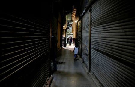 People walk near rows of closed shops at a popular tourist area in the Khan el-Khalili market, at al-Hussein and Al-Azhar districts in old Islamic Cairo, Egypt August 18, 2016. Picture taken August 18, 2016. REUTERS/Amr Abdallah Dalsh