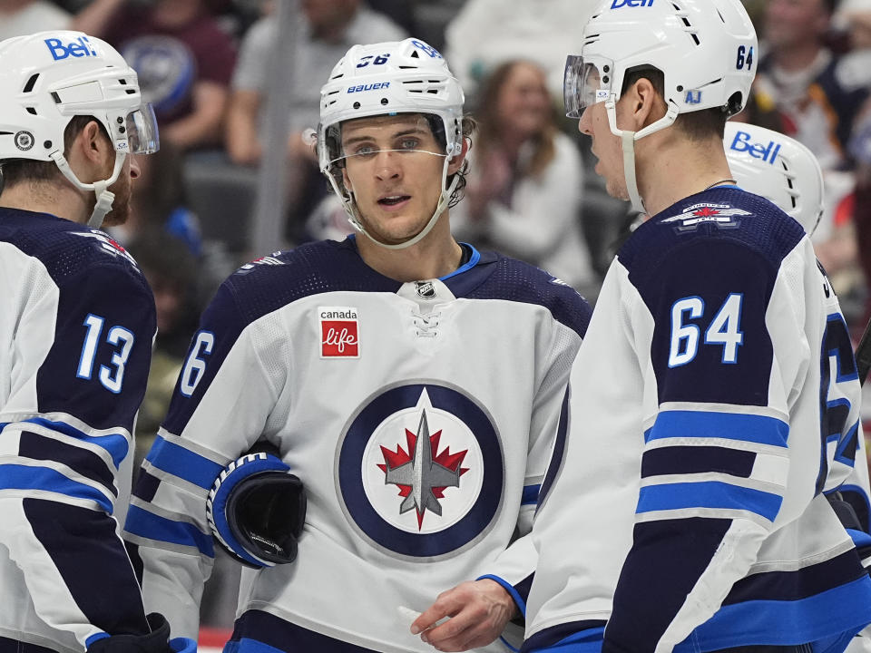 From left to right, Winnipeg Jets center Gabriel Vilardi, center Morgan Barron and defenseman Logan Stanley confer in the third period of an NHL hockey game against the Colorado Avalanche, Saturday, April 13, 2024, in Denver. (AP Photo/David Zalubowski)